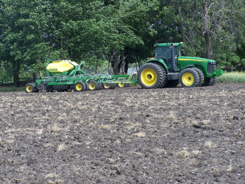 GPS-guided tractor pulling a seed planter on a farm in Kansas, USA